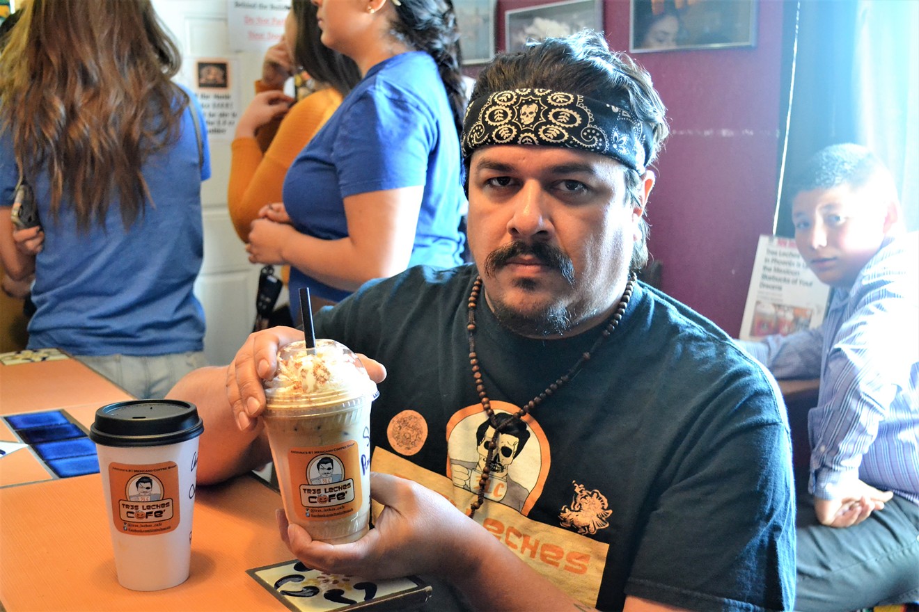ET Rivera of Tres Leches Café holds a pumpkin horchata latte from the shop's fall drink menu.