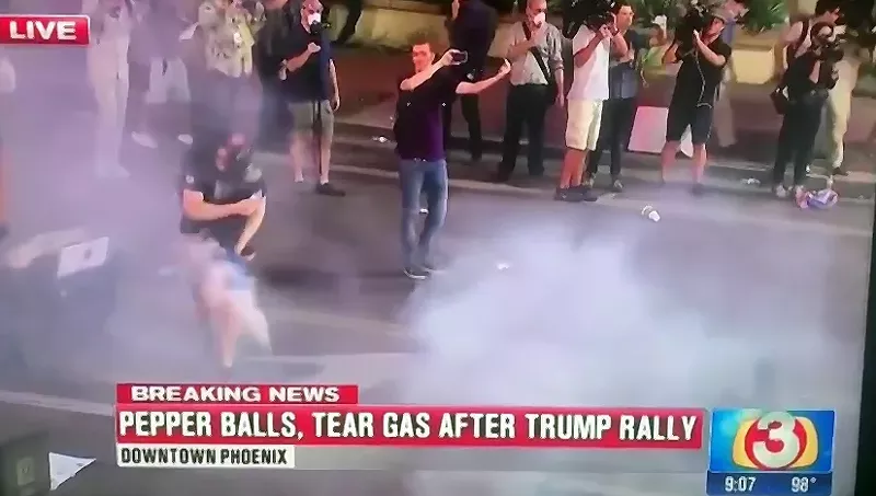 Image: A protester is hit in the groin with an object fired by police.