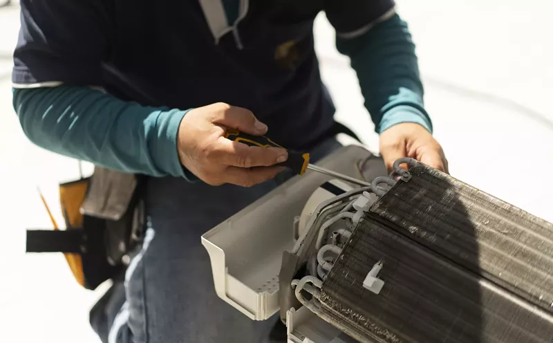 Image: an HVAC repair person at work