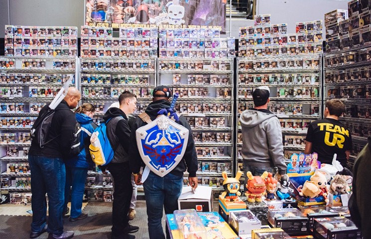 Attendees of the Ace Comic Con in New York check out a wall of Funko Pop dolls. - JASON LABOY