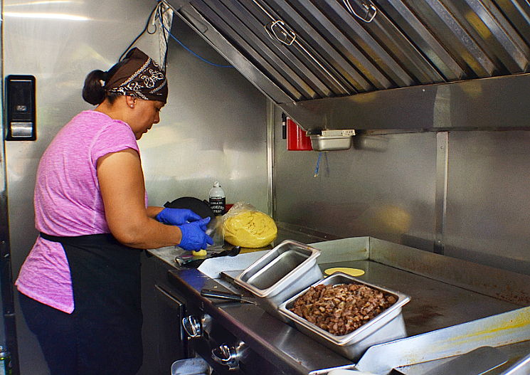 Lorena Martinez presses corn tortillas inside the D Taco Pit food truck in Laveen. - PATRICIA ESCARCEGA