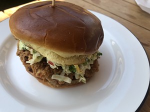 A fried chicken thigh sandwich with slaw. - CHRIS MALLOY