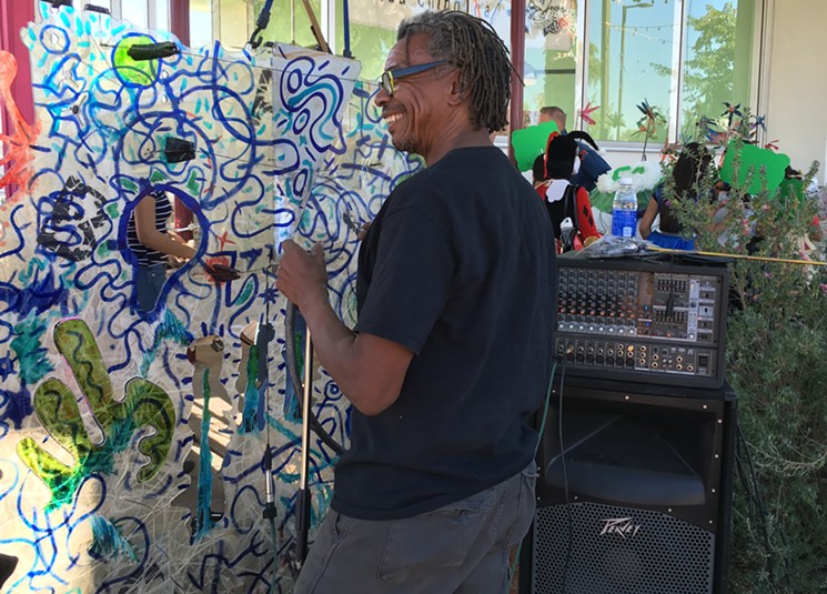 Joe Willie Smith plays one of his musical art installations on Grand Avenue. - LYNN TRIMBLE