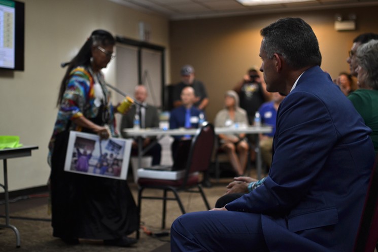 Scott Tressler of the Arizona Mining Association looks on as Sandra Rambler of the San Carlos Apache finishes speaking at the public hearing in Tempe on October 10, 2019. - ELIZABETH WHITMAN