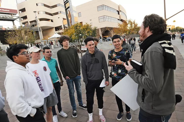 A street preacher speaks with attendees of Awaken 2020 outside of Sun Devil Stadium in Tempe. - BENJAMIN LEATHERMAN