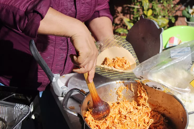 Sandra Felicidad Cervera Gallardo fills a tortilla with tinga before she slips it into the oil. - JOSÉ-IGNACIO CASTAÑEDA
