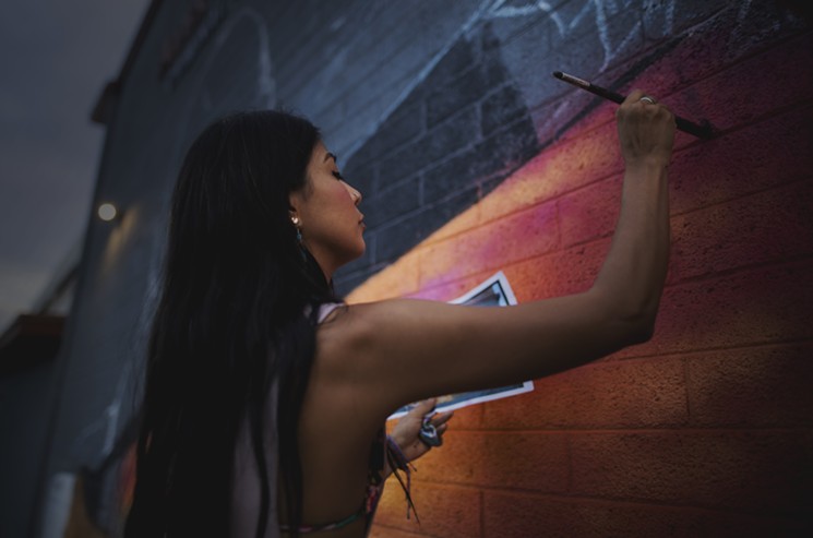 Still shot from the film La Morena, which shows the artist painting a Phoenix mural. - MANGO SKIES FILMS