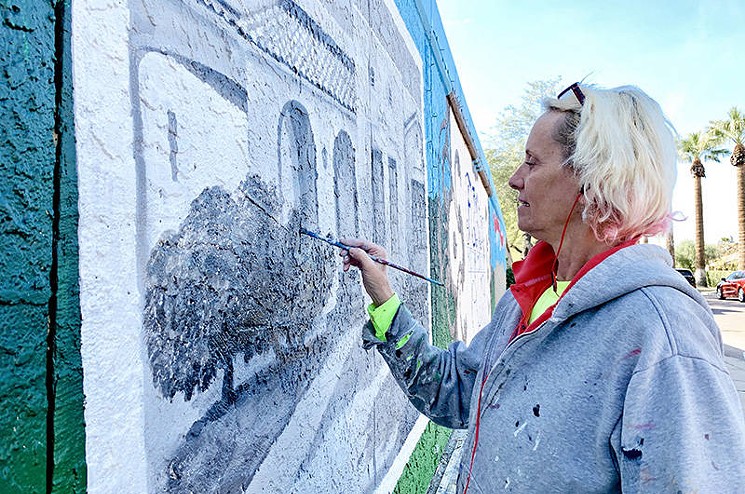 Lucretia Torva works on the commemorative mural. - STEVE DREISESZUN
