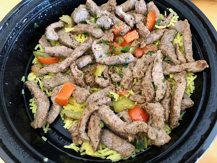 Yogurt-marinated slices of shawarma gyro, heavily layered over basmati saffron rice. - LAUREN CUSIMANO