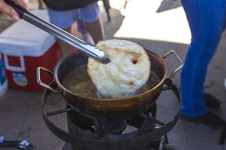 A fresh frybread is plucked from the fryer. - ZEE PERALTA
