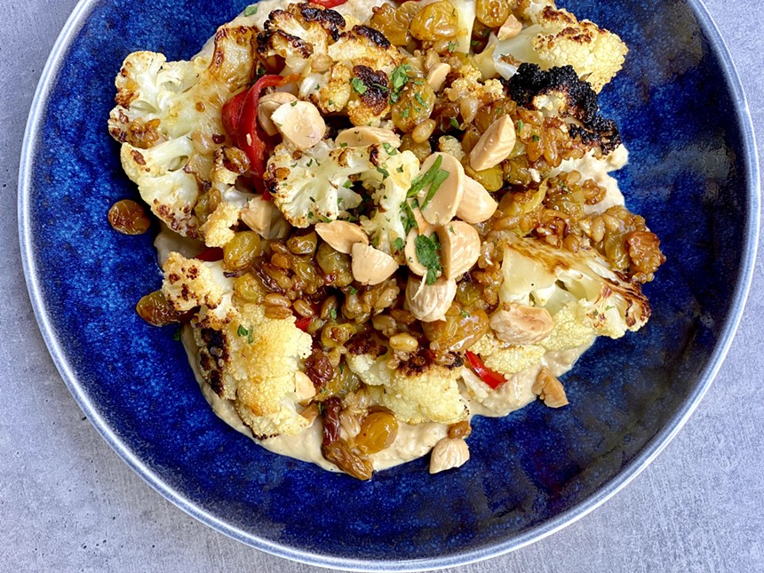 Happy hour cauliflower is a dive in delight of creamy hummus, sweet golden raisins, and buttery Marcona almonds. - ALLISON YOUNG