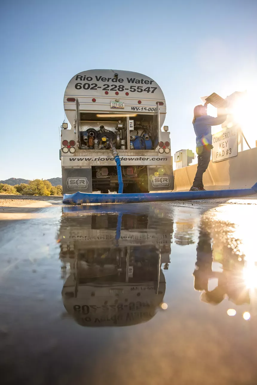 John Hornewer, co-founder of Rio Verde Water, connects his water hauling truck to the Scottsdale water station. - ZEE PERALTA