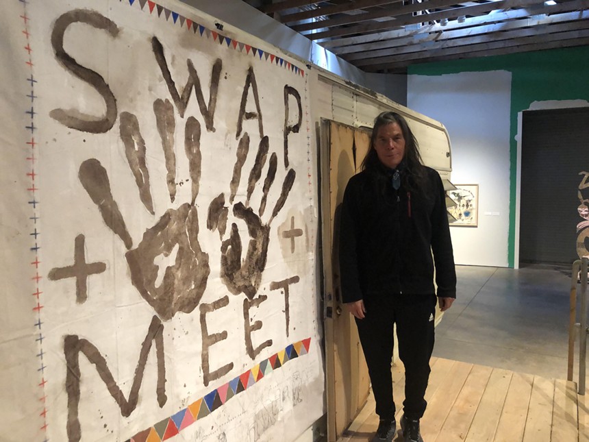 Artist Brad Kahlhamer stands with the centerpiece of his "Swap Meet" exhibition. - JENNIFER GOLDBERG
