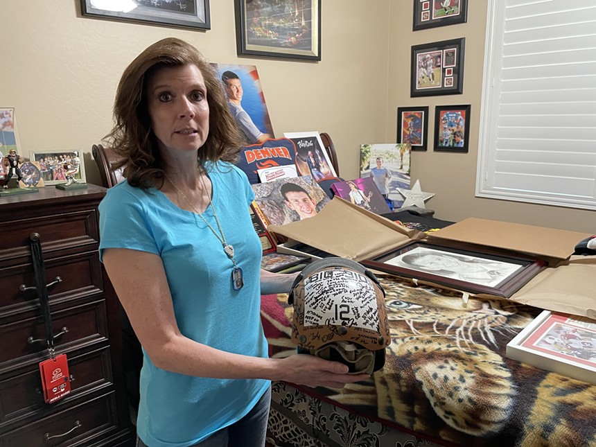 Teri Caserta holds her son Brandon's flight deck helmet that was signed by members of his squadron. When Brandon died by suicide in 2018, he removed his helmet and threw himself into the spinning tail rotor of a helicopter. - SCOTT BOURQUE