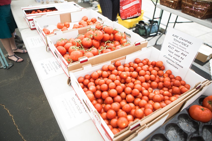 Trays of tomatoes at a farmers market.