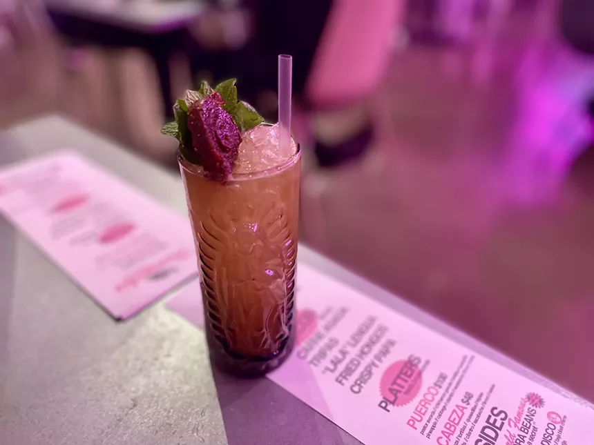 A cocktail sits on top of menus at Huarachis.