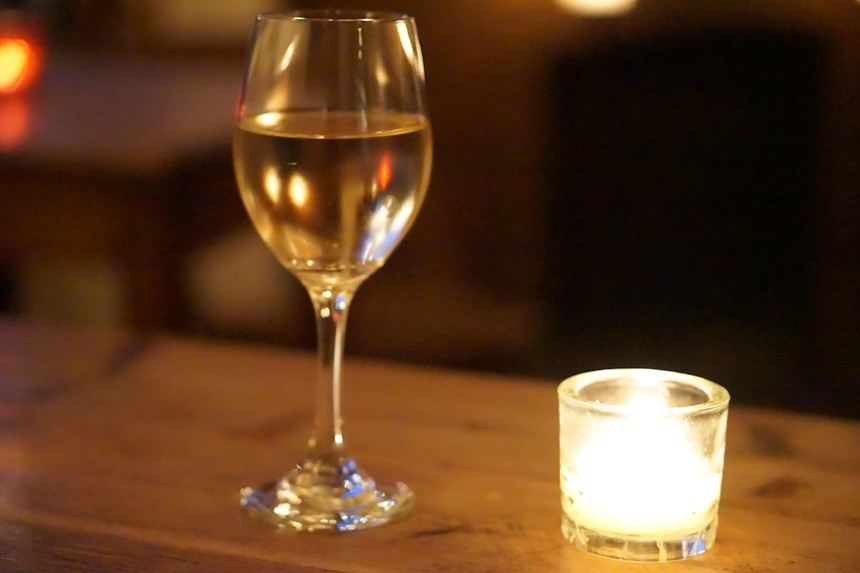 Glass of white wine and candle.