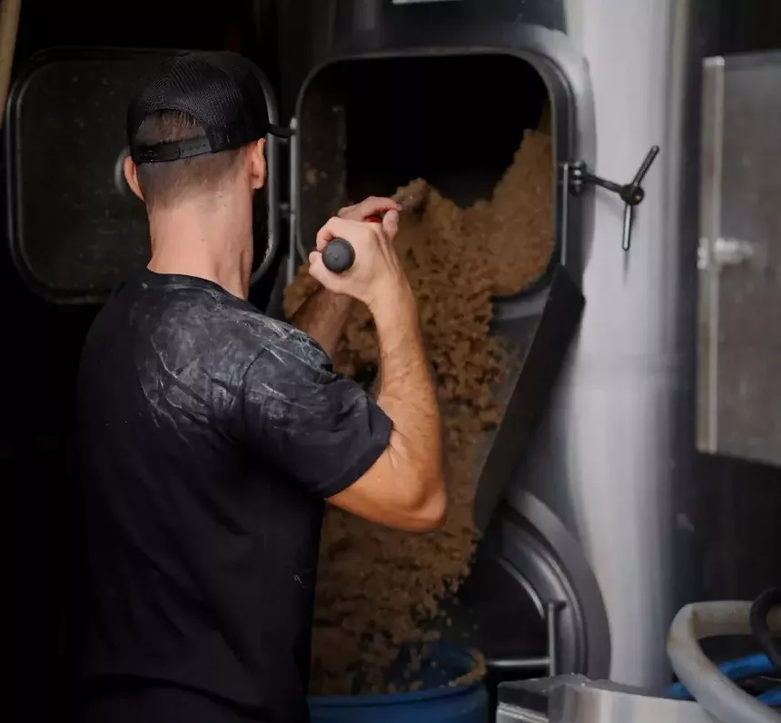 Emptying grain out of a brewery vat.