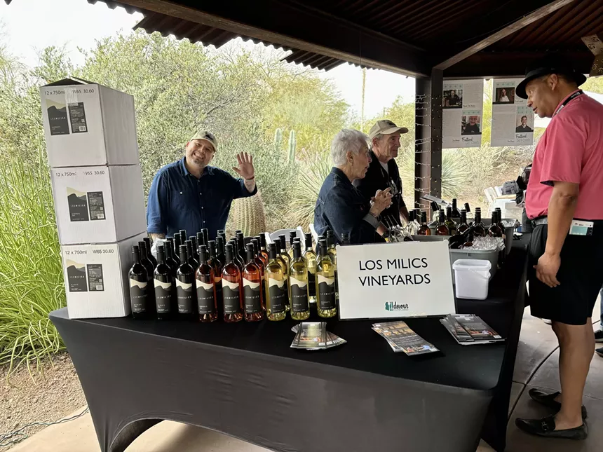 Pavle Milic waves at his winery's table.
