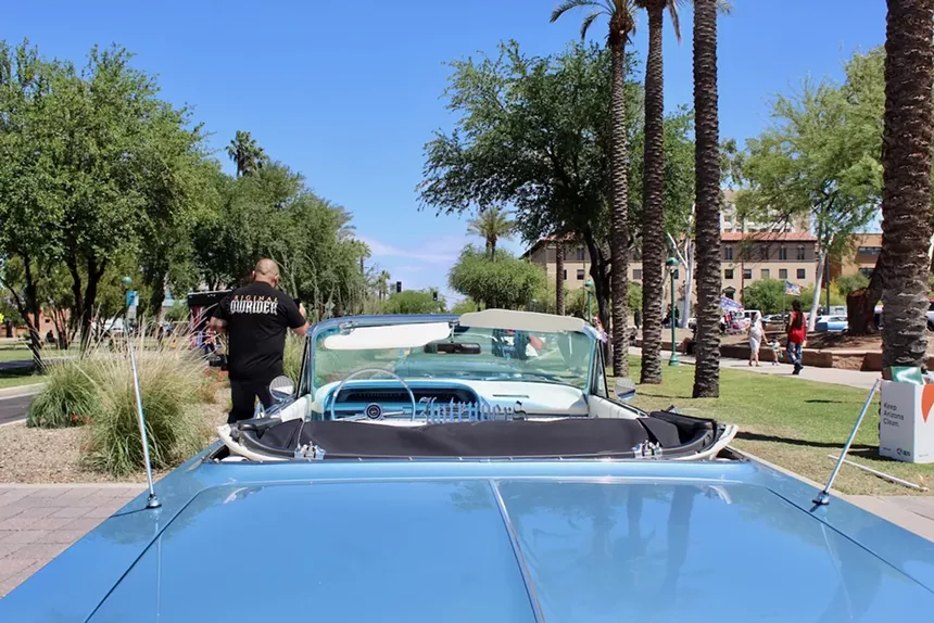 A blue convertible as viewed from behind the car.