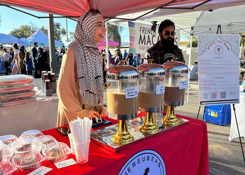 Two people serving coffee at a festival.