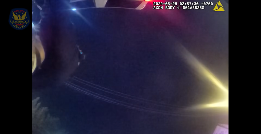 Body-cam footage looking into a night sky. In the top left corner, the back of a police officer and be seen.