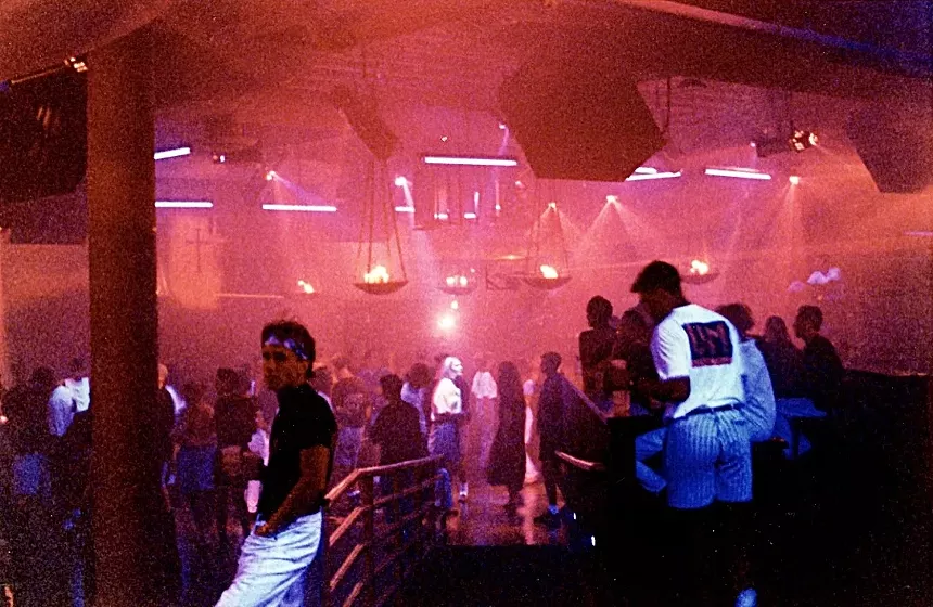 The interior of a red-tinged nightclub.