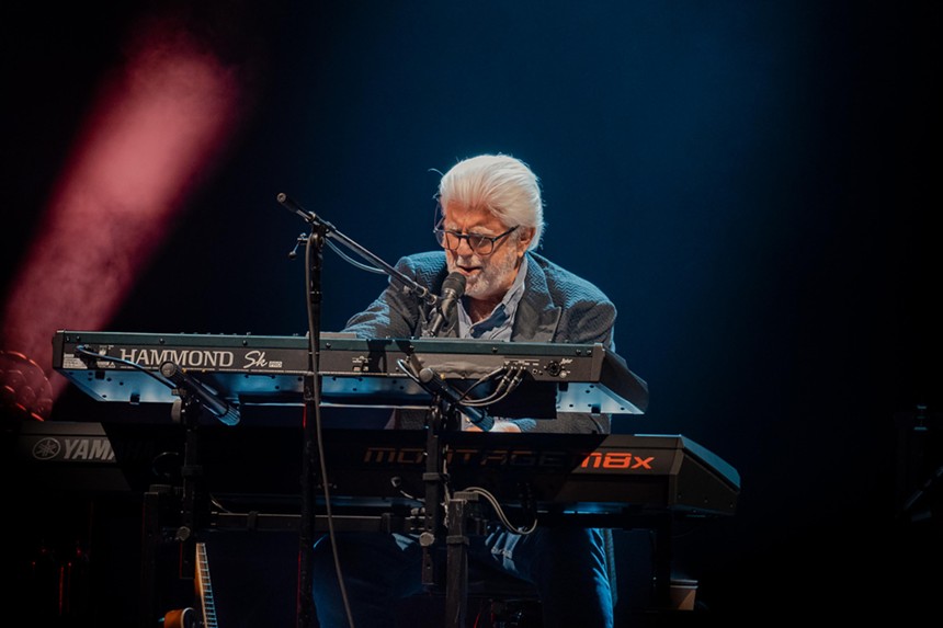 A man playing the keyboards during a concert.