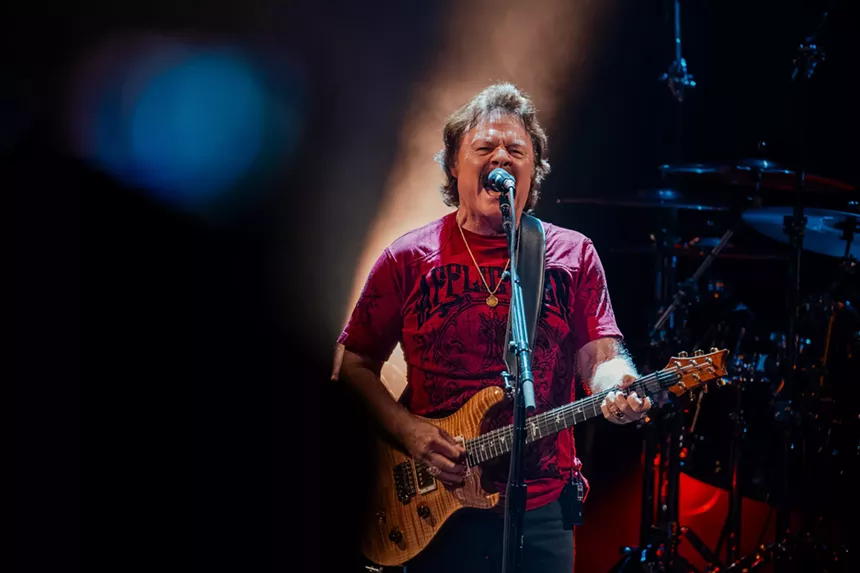 A man singing and playing guitar.