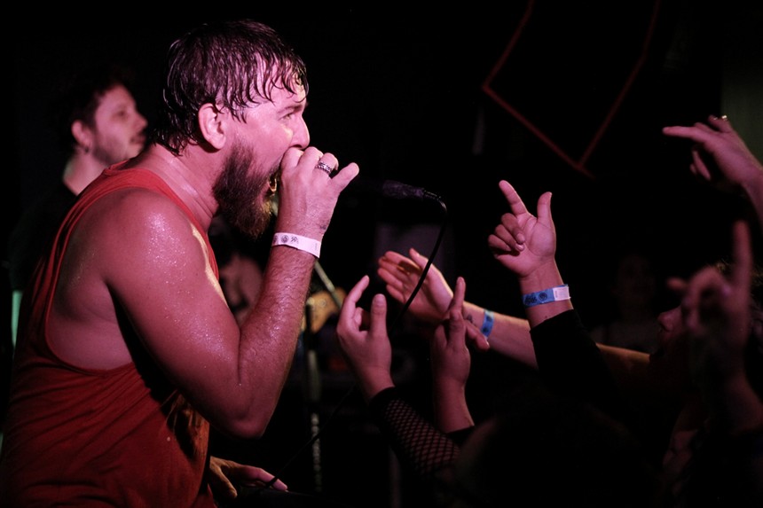 A sweaty man singing at a concert.