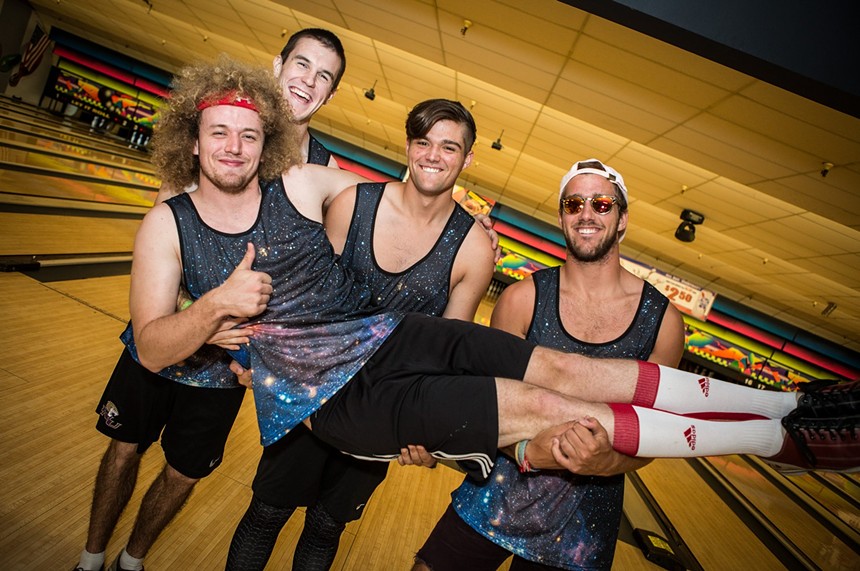 Men posing at a bowling alley.