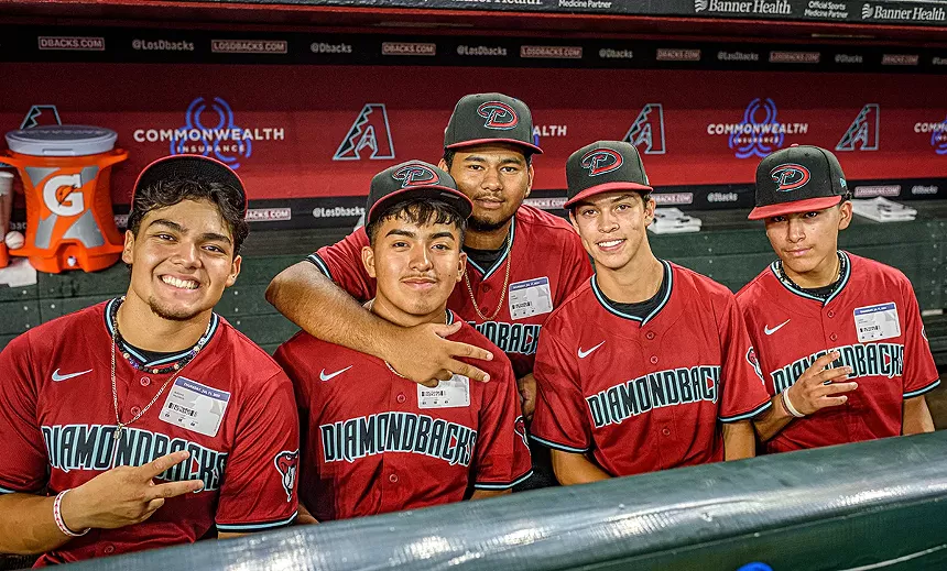 boys pose for a photo in red baseball jerseys