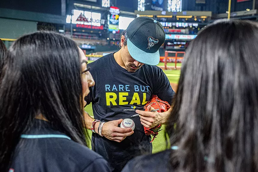 Corbin Carroll signs a baseball