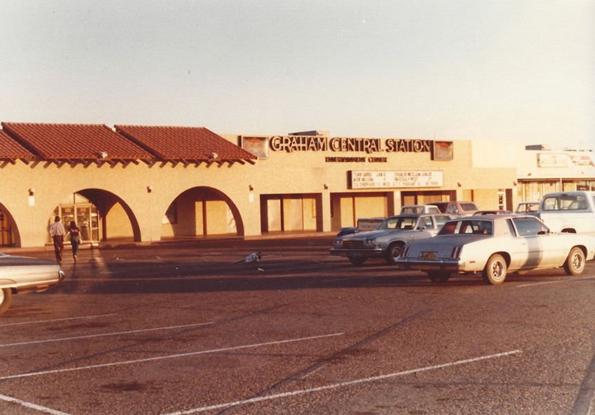 Exterior photo of a nightclub with cars parked in front.