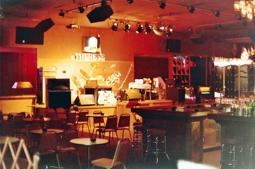 A bar, seating area and stage inside a nightclub.