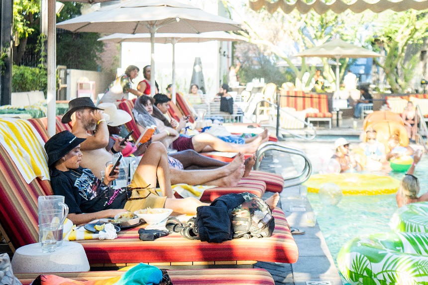 People in lounge chairs next to a pool