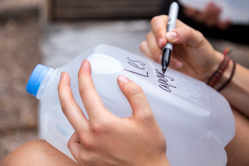 A person writes on a jug of water