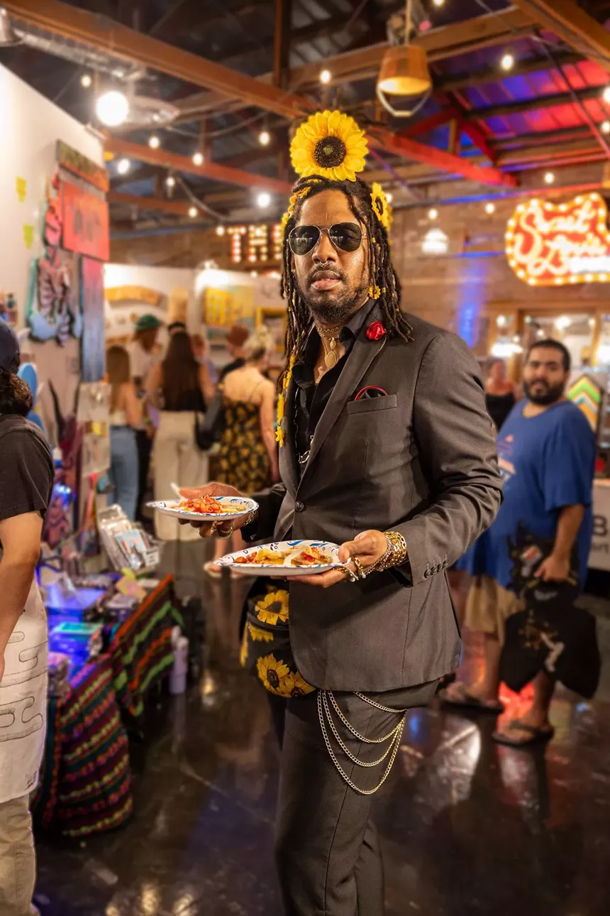 A Black man holding a plate of pancakes.