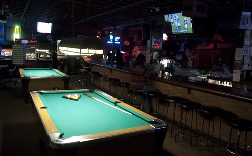 A pool table inside a bar.