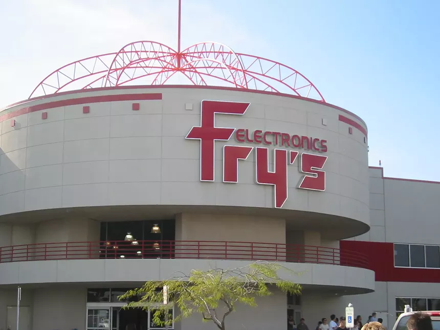 The entrance to a big-box electronics store in the daytime.