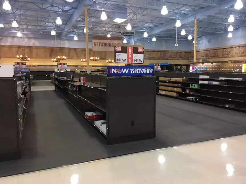 Empty shelves inside an electronics store.
