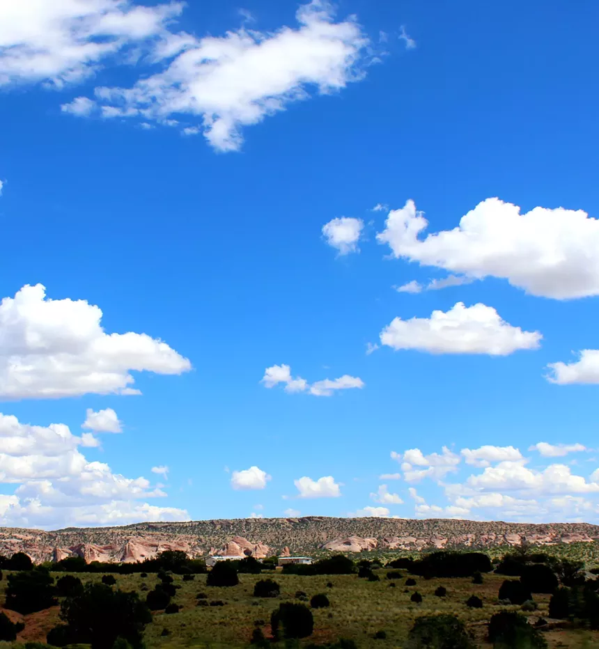 A big blue sky with mountains in the background.