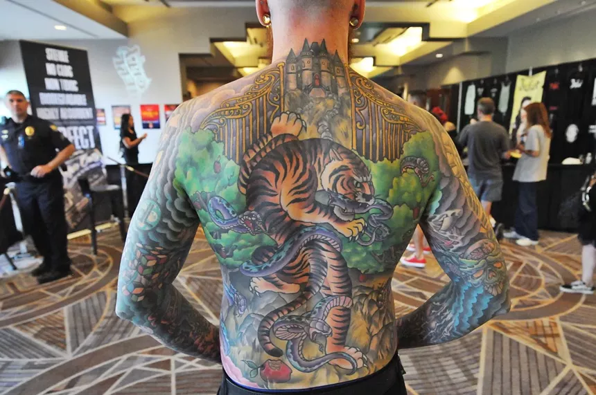 A male with large back tattoo featuring a tiger.