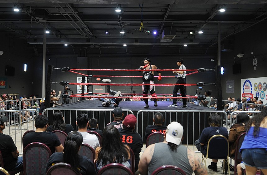 A crowd watching a pro wrestling match.