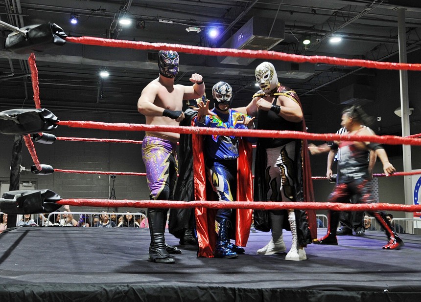 Three masked wrestlers pose in a wrestling ring.