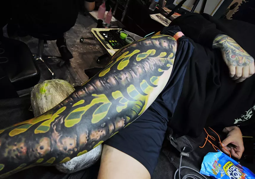 A creepy looking tattoo on a person's leg.