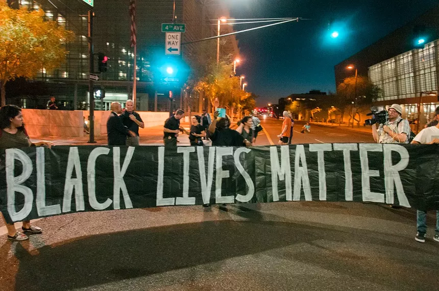 People protest holding up a banner.