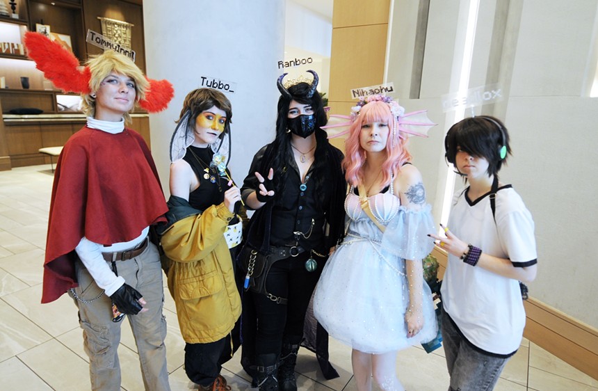 Five people wearing costumes stand in a line.