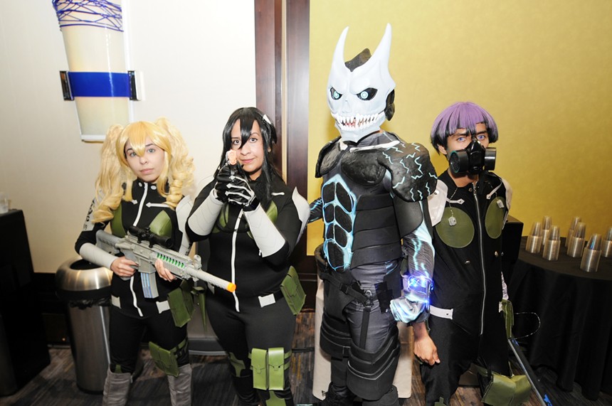 Four people in costume stand in a row.