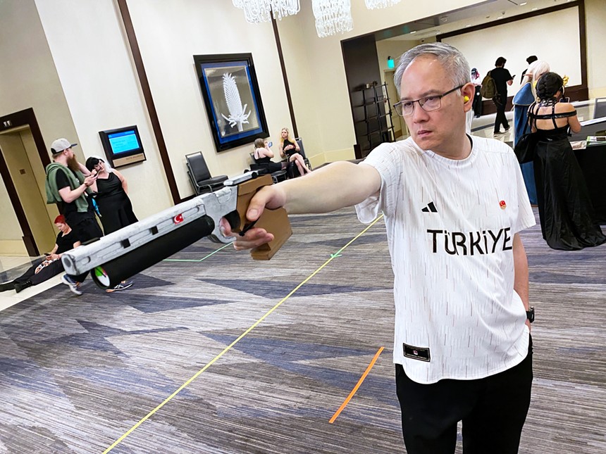 A man casually aiming a pistol.